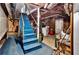 Basement staircase with blue carpeting, and an unfinished storage area at the bottom at 1774 Willis Mill Rd, Atlanta, GA 30311
