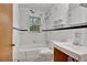 Bathroom with white tiled walls, dark trim, a toilet, and a tub under a window at 1774 Willis Mill Rd, Atlanta, GA 30311