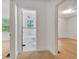 Hallway with doorways leading to a bathroom with black and white tiled floors and another room with hardwood floors at 1774 Willis Mill Rd, Atlanta, GA 30311