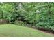 Spacious backyard featuring a grassy lawn and mature trees, creating a private and natural setting at 2612 Back Creek Chase, Dacula, GA 30019