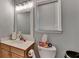 Half bathroom with vanity, modern faucet, large mirror, and toilet at 2612 Back Creek Chase, Dacula, GA 30019
