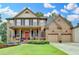 Charming two-story brick home featuring a well-manicured lawn, a welcoming covered porch and a two car garage at 2612 Back Creek Chase, Dacula, GA 30019