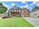 Beautiful brick home featuring manicured lawn, two car garage, covered porch and a bright red front door at 2612 Back Creek Chase, Dacula, GA 30019