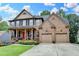 Brick home features a well-maintained lawn, an inviting covered front porch, and a two-car garage at 2612 Back Creek Chase, Dacula, GA 30019
