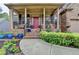 Inviting front porch with a colorful landscaped garden leading up to a bright red front door at 2612 Back Creek Chase, Dacula, GA 30019