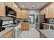 Kitchen with stainless steel refrigerator, range, microwave, tile floors, and light wood cabinets at 2612 Back Creek Chase, Dacula, GA 30019
