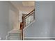 Staircase and living room featuring white risers, a wooden handrail, and neutral walls at 2612 Back Creek Chase, Dacula, GA 30019