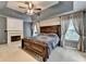 Comfortable primary bedroom with neutral paint, fireplace, and natural lighting at 2612 Back Creek Chase, Dacula, GA 30019