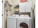 Functional laundry room equipped with a washer, dryer, and storage cabinets at 4588 Pine Se St, Smyrna, GA 30080