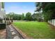 A spacious, well-maintained backyard with lush green grass, mature trees, and a privacy fence at 74 Knights Ct, Dallas, GA 30157