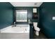 Bathroom featuring a corner soaking tub with accent plants, and a nearby toilet at 74 Knights Ct, Dallas, GA 30157