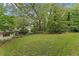 Spacious backyard with lush green grass, mature trees, and partial view of the home at 2596 Midway Rd, Decatur, GA 30030