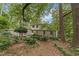 View of the home from the backyard showing mature trees and stone and siding exterior at 2596 Midway Rd, Decatur, GA 30030
