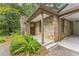 Inviting stone entrance featuring a charming wood door and professionally landscaped greenery at 2596 Midway Rd, Decatur, GA 30030
