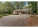 Exterior view of the home and a driveway with carport, surrounded by mature trees at 2596 Midway Rd, Decatur, GA 30030