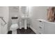 Charming powder room features a pedestal sink, modern fixtures, and dark wood flooring at 267 Snow Owl Way, Lawrenceville, GA 30044