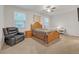 Spacious bedroom with large windows, ceiling fan, and a comfortable sitting area with recliner at 267 Snow Owl Way, Lawrenceville, GA 30044