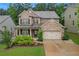 Charming two-story home with brick facade, covered front porch, two-car garage, and lush landscaping at 267 Snow Owl Way, Lawrenceville, GA 30044