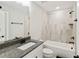 Bathroom featuring granite counters, white cabinets, and neutral-toned tile in shower-tub combination at 3525 Montebello Pkwy, Cumming, GA 30028