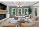 Cozy living room featuring a stone fireplace, coffered ceilings, and large windows overlooking the lush greenery at 3525 Montebello Pkwy, Cumming, GA 30028