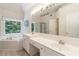 Well-lit bathroom with a tub and dual sinks at 3780 Summit Gate Dr, Suwanee, GA 30024