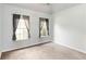 This is a simple bedroom with carpet flooring, neutral paint, and two windows with dark curtains at 3780 Summit Gate Dr, Suwanee, GA 30024