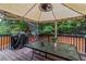 A covered deck features an outdoor dining area and a grill, perfect for entertaining at 3780 Summit Gate Dr, Suwanee, GA 30024