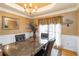 Dining room featuring decorative wainscotting, large window and designer light fixture at 3780 Summit Gate Dr, Suwanee, GA 30024