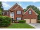 Charming brick two-story home with manicured lawn and attached two-car garage at 3780 Summit Gate Dr, Suwanee, GA 30024