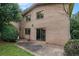 Exterior view of the backyard showcasing a brick home with sliding glass doors and a concrete patio at 3946 Flakes Mill Rd, Decatur, GA 30034