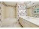 Bright bathroom featuring floral wallpaper, bathtub, and vanity sink at 5545 Durrett Dr, Atlanta, GA 30338