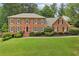 Charming brick home featuring a well-manicured lawn, mature trees, and traditional shutters at 5545 Durrett Dr, Atlanta, GA 30338
