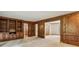 Bright living room features wood paneling, built-in bookshelves, and neutral carpet at 5545 Durrett Dr, Atlanta, GA 30338