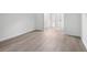 Bright bedroom leading to the bathroom with light grey wood flooring at 1931 Brian Way, Decatur, GA 30033
