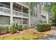 Exterior of multi-story condo building showing patios, siding, shrubbery, and walkway at 1931 Brian Way, Decatur, GA 30033