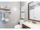Stylish bathroom featuring a granite countertop, framed mirror, and decorative artwork at 327 Nobleman Way, Canton, GA 30114