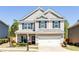 Charming two-story home featuring neutral siding, black shutters, and a well-manicured front lawn at 327 Nobleman Way, Canton, GA 30114