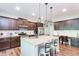 Spacious kitchen features granite counters, brown cabinetry, stainless appliances, and a breakfast bar at 327 Nobleman Way, Canton, GA 30114
