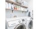 Well-organized laundry room features a front load washer and dryer and storage shelves at 327 Nobleman Way, Canton, GA 30114