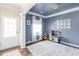 Inviting playroom with blue accent wall, white trim, natural light, and unique chandelier at 327 Nobleman Way, Canton, GA 30114
