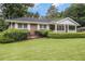 Inviting brick home with a charming front porch and mature landscaping at 4125 Lindsey Dr, Decatur, GA 30035
