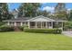 Charming brick home with a well-manicured lawn, trimmed hedges and a covered porch at 4125 Lindsey Dr, Decatur, GA 30035
