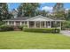 Charming brick home featuring a well-manicured lawn and a covered front porch at 4125 Lindsey Dr, Decatur, GA 30035