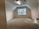 Carpeted attic space with natural light from a window at 636 Lantern Park Ln, Scottdale, GA 30079