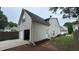 View of the backyard showing a two-car garage, fenced-in yard, and landscaped details at 636 Lantern Park Ln, Scottdale, GA 30079