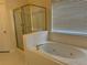 Bathroom featuring a shower and jetted tub next to a window with blinds at 636 Lantern Park Ln, Scottdale, GA 30079
