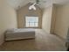 Bright bedroom with a ceiling fan, neutral carpeting, and large window allowing for ample natural light at 636 Lantern Park Ln, Scottdale, GA 30079