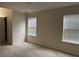 Bright bedroom featuring neutral walls, carpet, and two windows for natural light at 636 Lantern Park Ln, Scottdale, GA 30079
