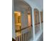 Upstairs hallway with archways, wood railings, and a view to the ensuite bath at 636 Lantern Park Ln, Scottdale, GA 30079