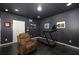 Basement room with dark walls, wood floor, a treadmill and a leather recliner at 1661 Hammock Dr, Smyrna, GA 30080